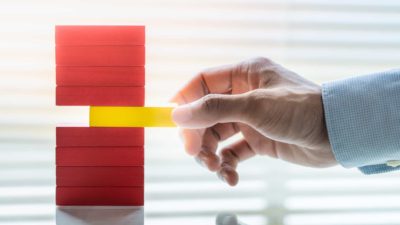 man about to pull middle block out of a pile of blocks