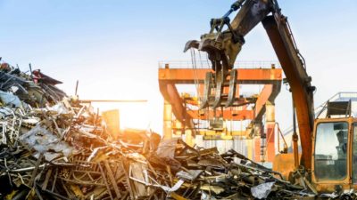 pile of scrap metal being sorted by crane representing sims share price