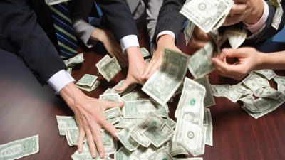 hands all grabbing at cash representing US shares