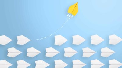 Yellow paper plane flying high above other paper planes representing asx travel shares.