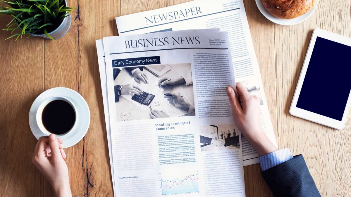man reading business newspaper with coffee