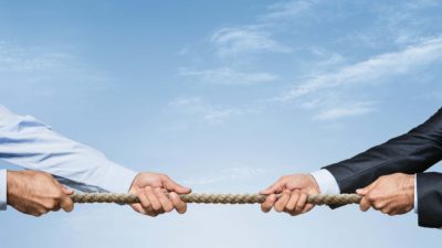 Western Areas takeover Mainstream share price takeover M&A bidding war asx shares asset sales and mergers and acquisitions represented by two business men playing tug of war with rope Cleanaway share price