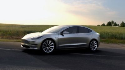 tesla stock represented by tesla electric car driving along country road