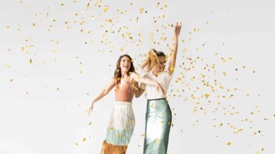 two fashionable asx investors dancing among confetti