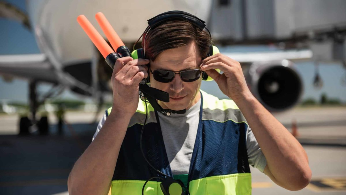airline ground crew worker standing in front of jet plane