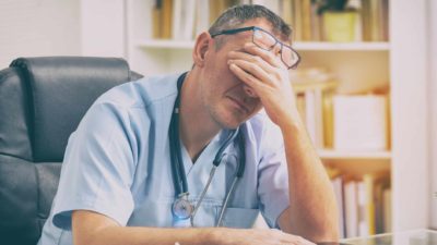 falling healthcare asx share represented by doctor with head in hands
