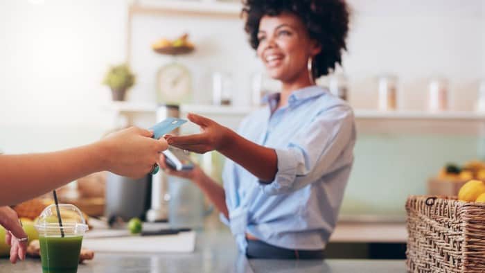 Female cafe employee accepting a card as payment