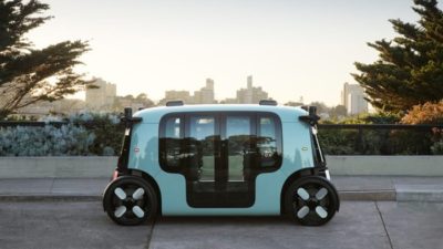 Zoox electric vehicle parked against city scape