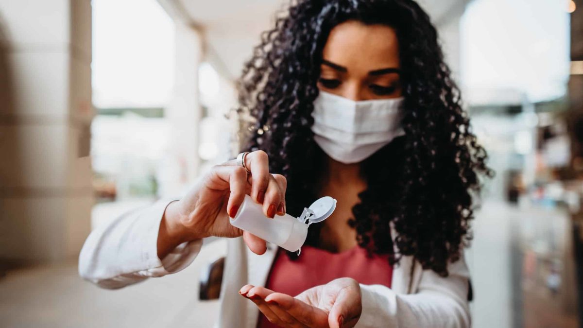 woman cleaning her hands with antibacterial gel - hand sanitizer