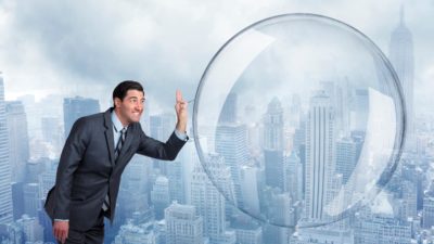 a man in a business suit leans in to burst a huge bubble with a pin, indicating a major share market crash