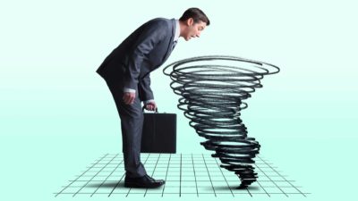 a businessman looks into a graph on the floor as a tornado rises, indicating share market chaos