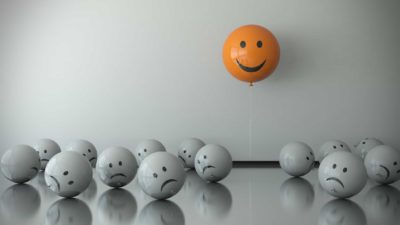 party of asx shares represented by happy orange balloon floating above sad grey balloons