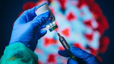 covid vaccine stocks represented by doctor drawing vaccine from vial