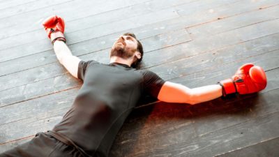 Boxer falls down in the ring, indicating a share price performance low.