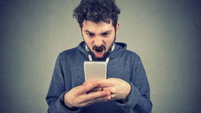 An unhappy customer looks at his mobile phone, indicating trouble for an ASX company