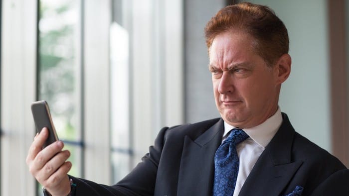 ASX shares investor looking incredulously at phone