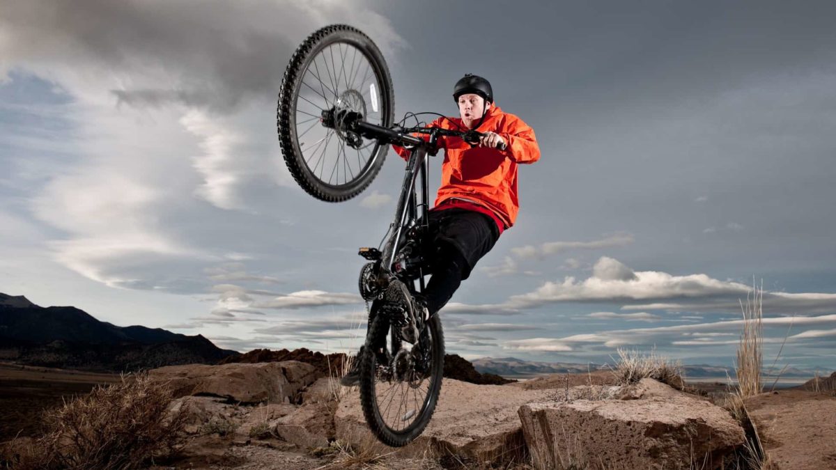 A man doing a wheelie on his bicycle, indicating a share price rise for ASX companies