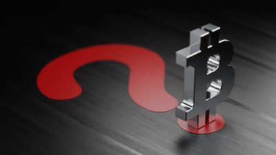 A Bitcoin symbol sits atop a red question mark, indicating uncertainty over the value of crypto currency
