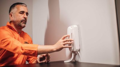 Insider trading and share price manipulation represented by man in jail reaching for phone