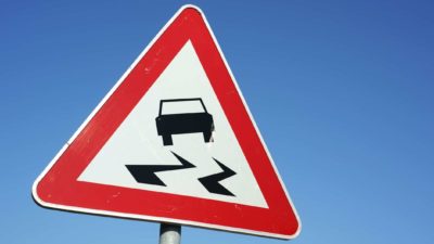 ASX share price slide represented by urban street sign with car sliding