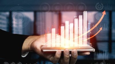 A hand holding a graph trending up, indicating a surging share price on the ASX