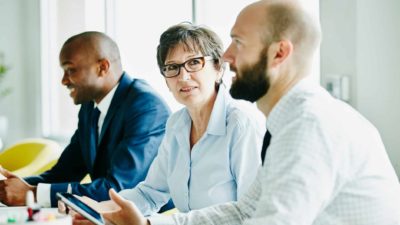 Three board members sit at a table.