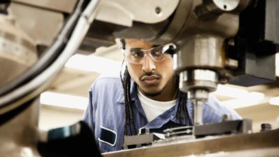 Male worker using machinery for manufacturing of Korvest cables and pipe supports