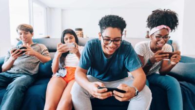 4 teenagers playing mobile game