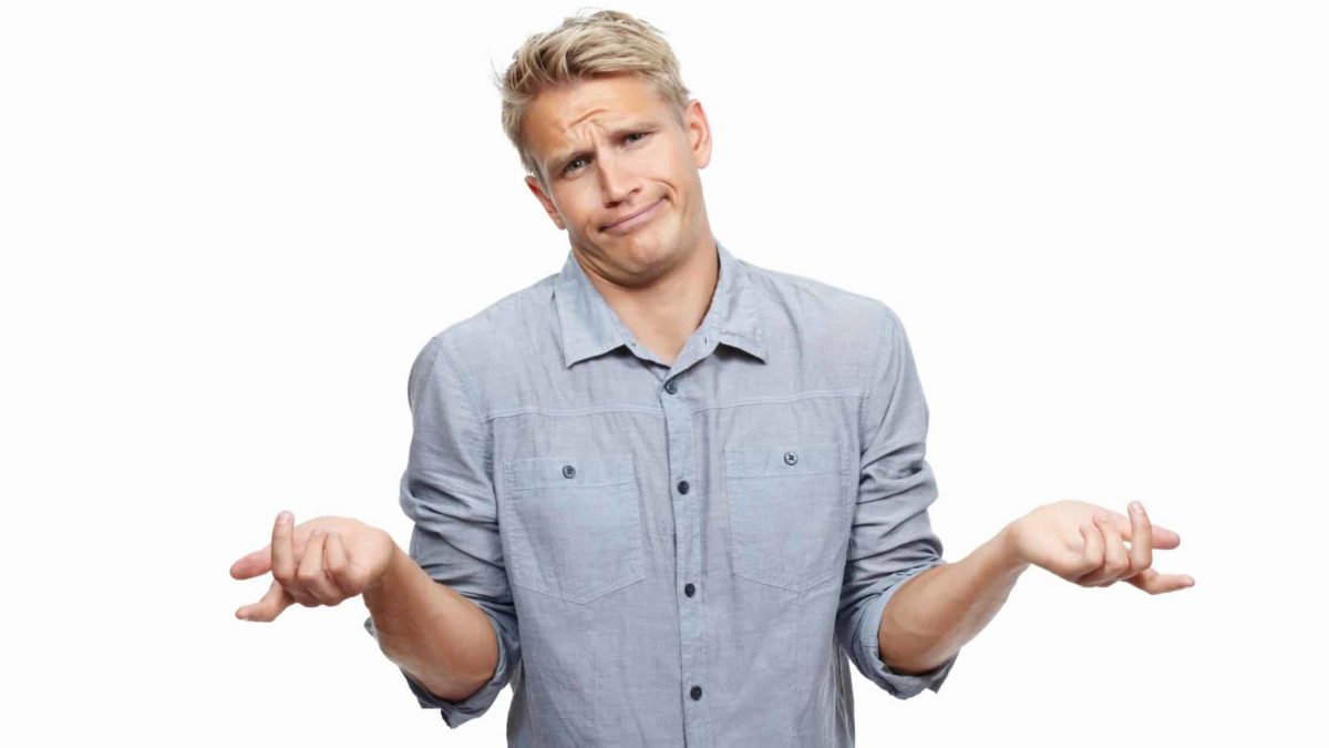 A man with blonde hair wearing a checked shirt shrugs at news of Origin's $2.21 billion sell-down