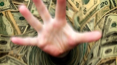 ASX 200 shares Australian dollar A hand gets sucked into a vortex of US dollar notes, indicating a threat to the ASX share market posed by a higher US dollar