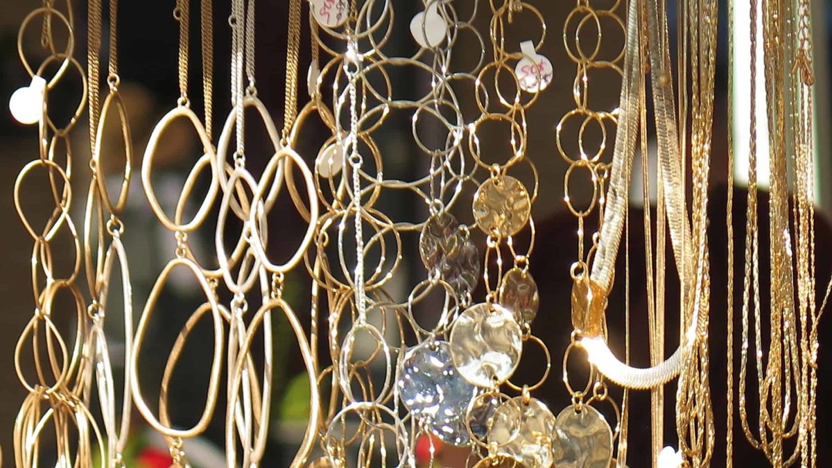 jewellery share price rise represented by lots of gold necklaces hanging in a row