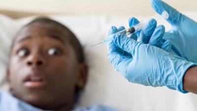 Medical asx share price fall represented by worried looking patient awaiting vaccine injection