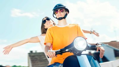 ASX share price represented by two people looking happy on electric scooter