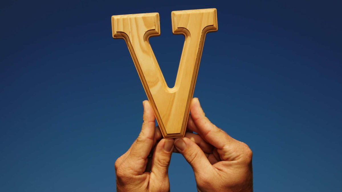 ASX tax loss buy Hands hold up the letter V, indicating a share price V-shaped recovery on the ASX