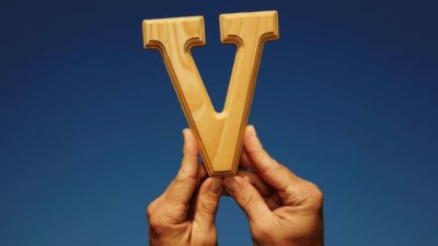 ASX tax loss buy Hands hold up the letter V, indicating a share price V-shaped recovery on the ASX