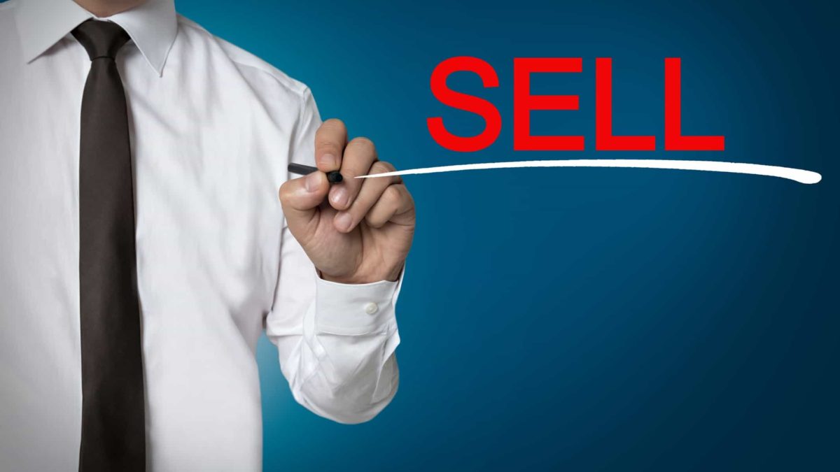 Business man marking Sell on board and underlining it