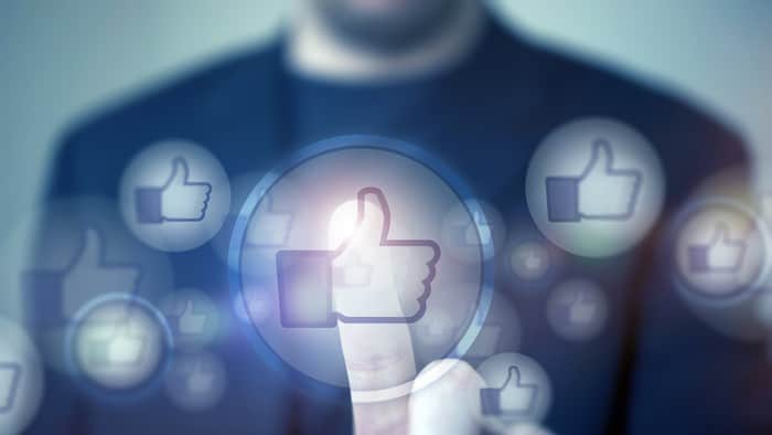 facebook thumbs up sign with a man in the background