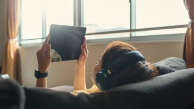 kid with headphones on watching a video on iPad
