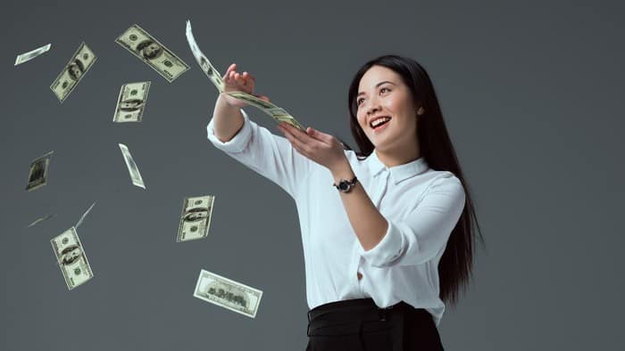 woman in white shirt splashing money in the air