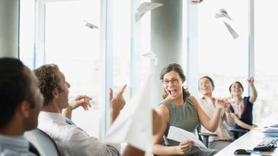 Excited office workers through paper in the air, inidcating a positive share price rise in ASX software and digital companies