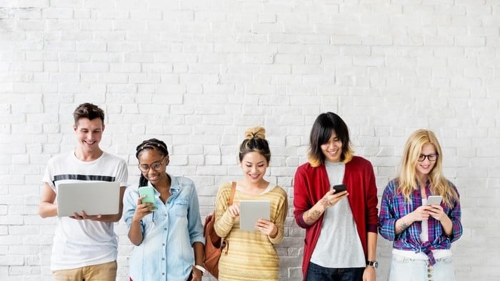 people lined up and using smart phones and laptops