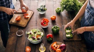 man and woman cutting vegetables up