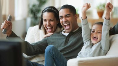 Family cheering in front of TV