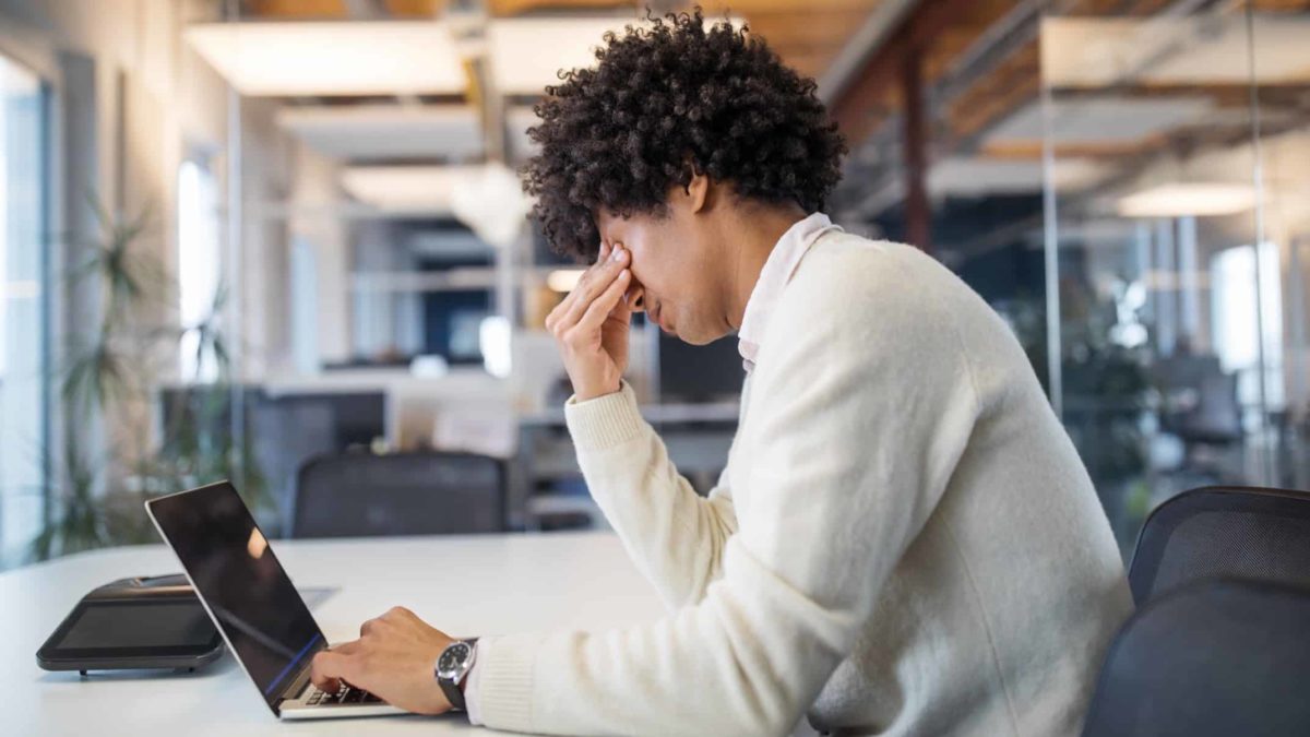 An investor with his head in his hands looking at falling asx share price on laptop