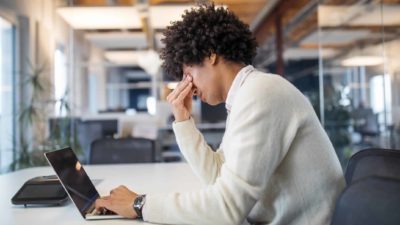 An investor with his head in his hands looking at falling asx share price on laptop