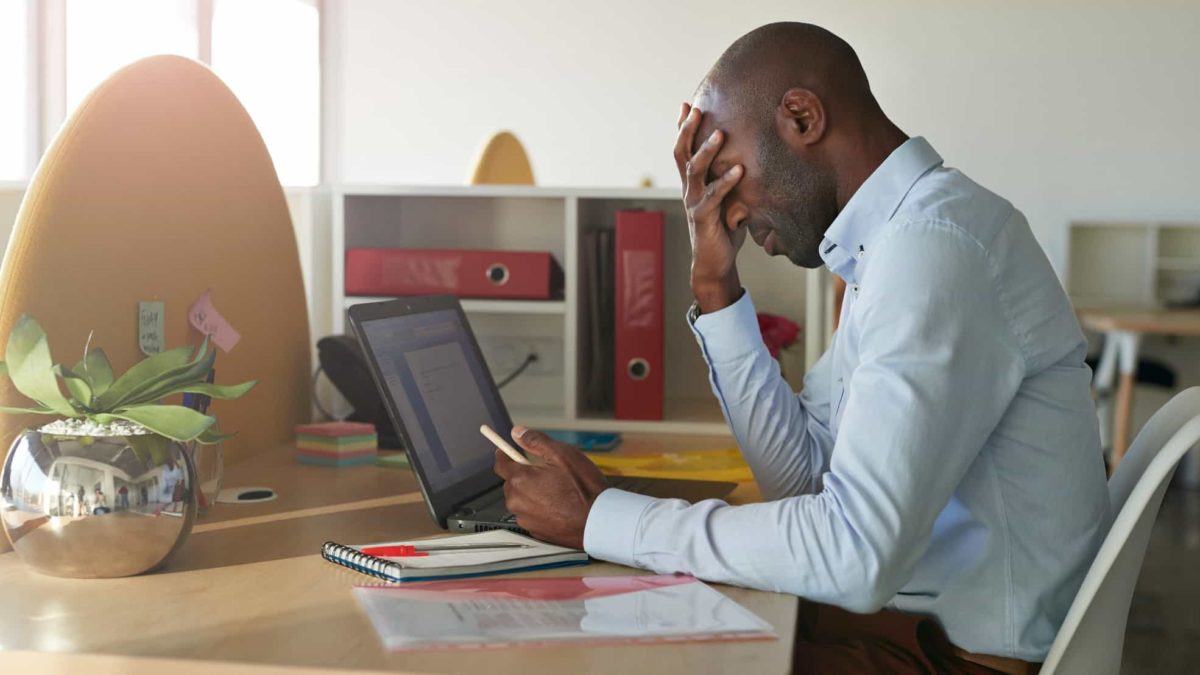 Man gets bad news at desk while looking at computer