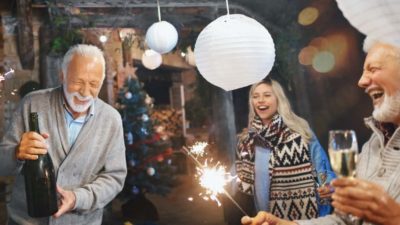 man celebrating with bottle of champagne at a party