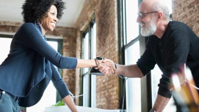 a man and woman agreeing to a deal with a handshake