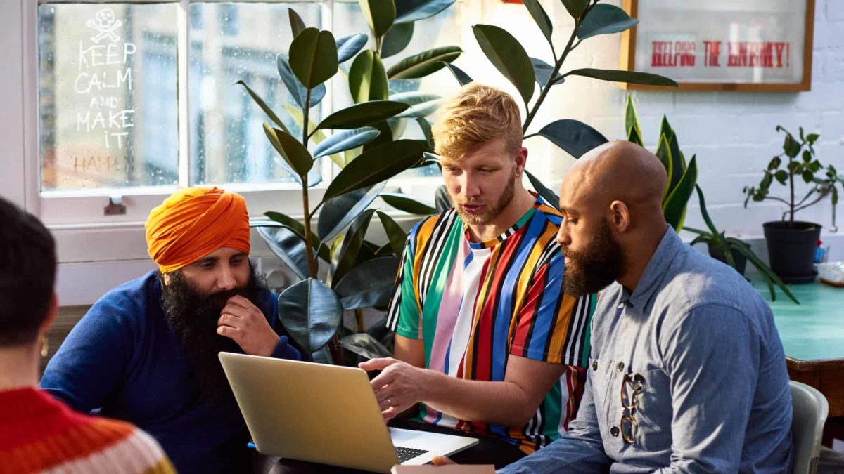 A discussion between colleagues using a laptop.
