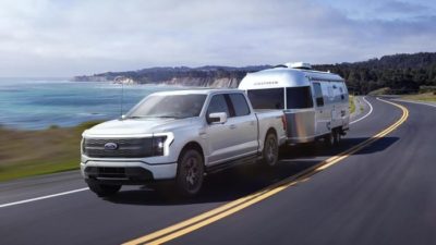 ford on the road with a trailer attached